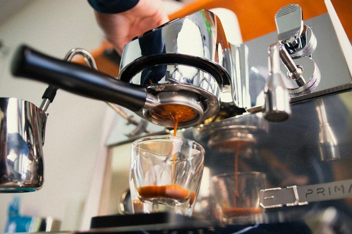Espressor cu portafiltru care extrage un espresso